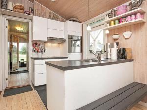 uma cozinha com armários brancos e uma bancada em 6 person holiday home in Frederikshavn em Frederikshavn