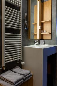 a bathroom with a sink and a mirror at Logis Hotel Restaurant La Tour in Dunières +23 photos