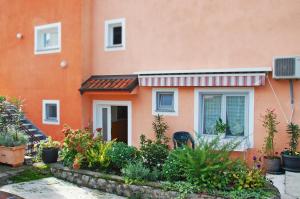 a orange house with plants in front of it at Apartments Skorup in Ičići