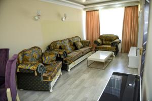 a living room with two couches and a tv at Goris Hotel in Goris