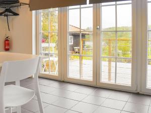 4 person holiday home in Sk rhamn في سكارهامن: مطبخ مع أبواب زجاجية منزلقة مع طاولة وكراسي