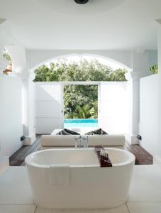 
a white bath tub sitting in a bathroom next to a window at Amara Sanctuary Resort Sentosa (SG Clean, Staycation Approved) in Singapore
