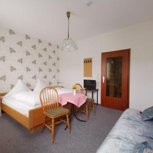 a bedroom with a bed and a table and chairs at Hotel Restaurant LAHNHOF in Dausenau