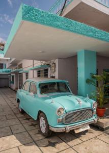 ein altes blaues Auto, das vor einem Gebäude parkt in der Unterkunft Jaipur 1727 Homestay in Jaipur