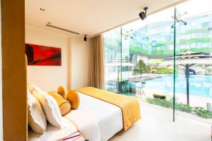 een slaapkamer met een bed en een groot raam bij Vivanta Bengaluru, Whitefield in Bangalore