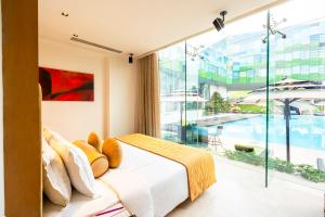 a bedroom with a bed and a large window at Vivanta Bengaluru, Whitefield in Bangalore