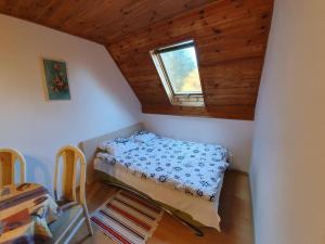 Dormitorio pequeño con cama en el ático en Zielony domek, en Krasnobród