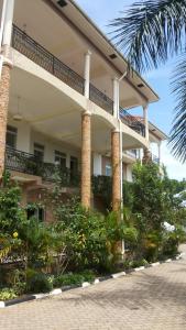 a building with pillars and plants in front of it at RoseVilla Hotel in Arua