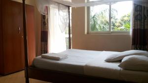 Postel nebo postele na pokoji v ubytování RoseVilla Hotel