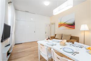 een witte eetkamer met een witte tafel en stoelen bij Apartment Rona Opatija Superior in Opatija