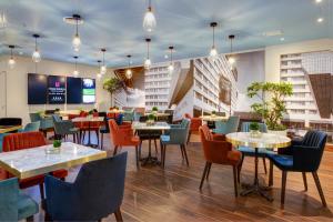 a restaurant with tables and chairs in a building at Copthorne Tara Hotel London Kensington in London
