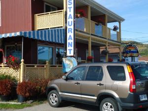 a car parked in front of a store at Hôtel-Motel Baie-Ste-Catherine in Baie-Sainte-Catherine