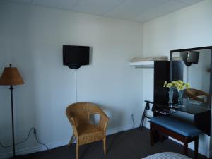 a living room filled with furniture and a tv at Hôtel-Motel Baie-Ste-Catherine in Baie-Sainte-Catherine