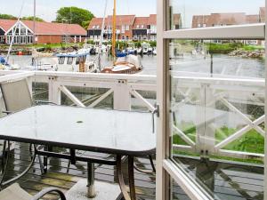 einen Balkon mit einem Tisch und Blick auf den Yachthafen in der Unterkunft 4 person holiday home in Borre in Borre