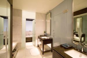 a bathroom with two sinks and a toilet and a mirror at The Anvaya Beach Resort Bali in Kuta