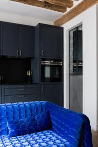 a blue couch in a kitchen with black cabinets at Veeve - Saint-Louis Style in Paris