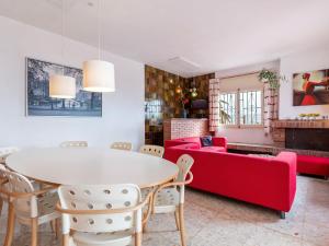 sala de estar con mesa y sofá rojo en Belvilla by OYO Cupedo, en Vinarós