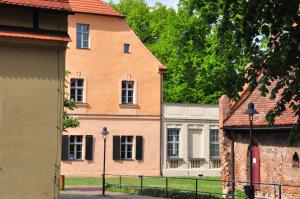 a large orange building with a fence in front of it at Zentrum Kloster Lehnin in Lehnin