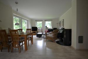 ボルンにあるFerienhaus Dineのテーブルと椅子のあるダイニングルームとリビングルーム