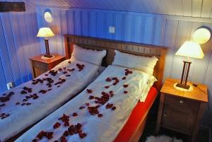 a bedroom with two beds with roses on the sheets at Regnbuegården in Røros