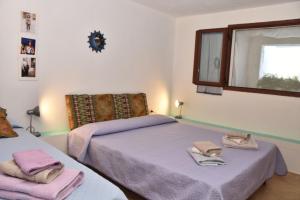 a bedroom with two beds and a window at Affittacamere Casa Maica in Stintino