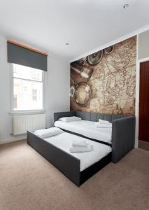 a bedroom with two beds and a map on the wall at Stewart by Heeton Concept - Aparthotel Edinburgh in Edinburgh