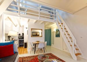a living room with a staircase and a table and chairs at La Cathédrale de Sel in Batz-sur-Mer
