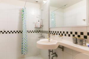 La salle de bains blanche est pourvue d'un lavabo et d'un miroir. dans l'établissement Eve Hongdae, à Séoul