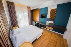 a hotel room with a bed and a television at Inada Hotel Ksamil in Ksamil