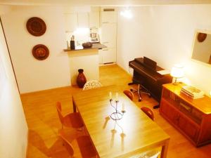 ein Wohnzimmer mit einem Tisch und einem Klavier in der Unterkunft Dimai House No 16 Dornbirn Zentrum in Dornbirn