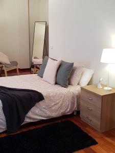 een slaapkamer met een bed met kussens en een spiegel bij Dúplex Nigrán in Nigrán