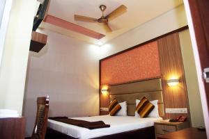 a hotel room with a bed and a ceiling fan at Hotel Indiana Inn in Navi Mumbai