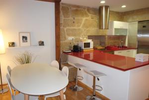 eine Küche mit einer weißen Theke und einem weißen Tisch in der Unterkunft Piso en antiguo palacete del casco histórico in Pontevedra
