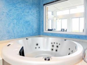 eine Badewanne im Bad mit blauen Wänden in der Unterkunft 8 person holiday home in Kalundborg in Kalundborg