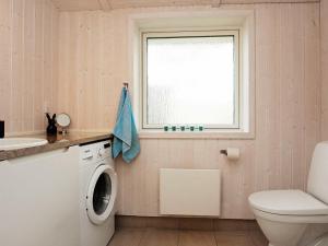 a bathroom with a washing machine and a window at 4 person holiday home in Slagelse in Slagelse