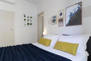 a bedroom with a large bed with yellow pillows at Biasanòt Mini in Bologna