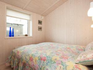 a bedroom with a bed with a floral bedspread and a window at 4 person holiday home in Slagelse in Slagelse