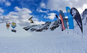 マイヤーホーフェンにあるMANNI home - rooms & apartmentsの雪上の滑り台から飛び降るスノーボーダー