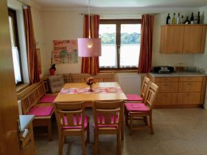 a kitchen with a table with pink cushioned chairs at Appartement Mary in Schladming