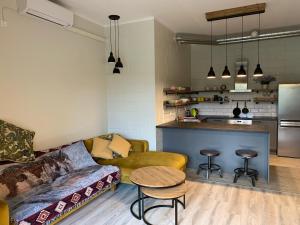 a living room with a couch and a kitchen at Murimäe Winery Guest Apartment in Truuta