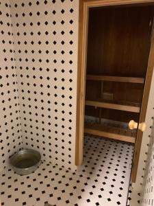 W łazience znajduje się wyłożona czarno-białymi kafelkami podłoga. w obiekcie Murimäe Winery Guest Apartment w mieście Truuta