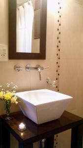 lavabo blanco en el baño con espejo en Maria del Bosque Apart Hotel / Cabañas en San Carlos de Bariloche