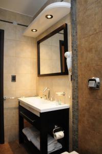 a bathroom with a sink and a mirror at Hotel Euzko Alkartasuna in Macachín