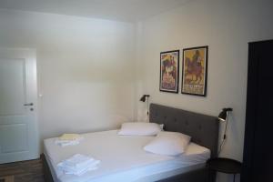 een slaapkamer met een bed met witte lakens en 2 kussens bij Apartments Mario with private parking in Makarska