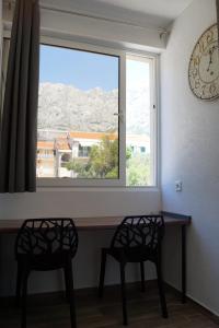 two chairs sitting at a table in front of a window at Apartments Mario with private parking in Makarska