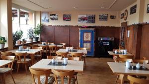 a restaurant with tables and chairs in a room at Landgasthof Frankentor in Wasserlosen