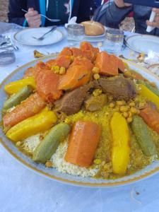 a plate of food with meat and vegetables on a table at Dar Ines in Moulay Idriss Zerhoun