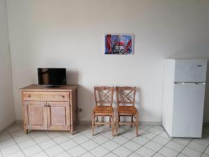 a kitchen with two chairs and a desk and a refrigerator at Il Castagno in Marciana