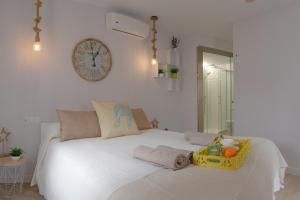 een slaapkamer met een wit bed met een klok aan de muur bij Obispo Fitero in Córdoba