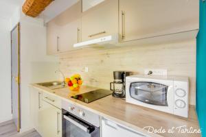 eine Küche mit Mikrowelle und Obst auf der Theke in der Unterkunft Enjoyable studio just by the sea - Dodo et Tartine in Toulon